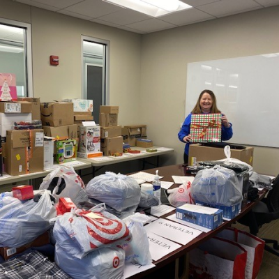 Employee helping wrap presents during volunteer charity event